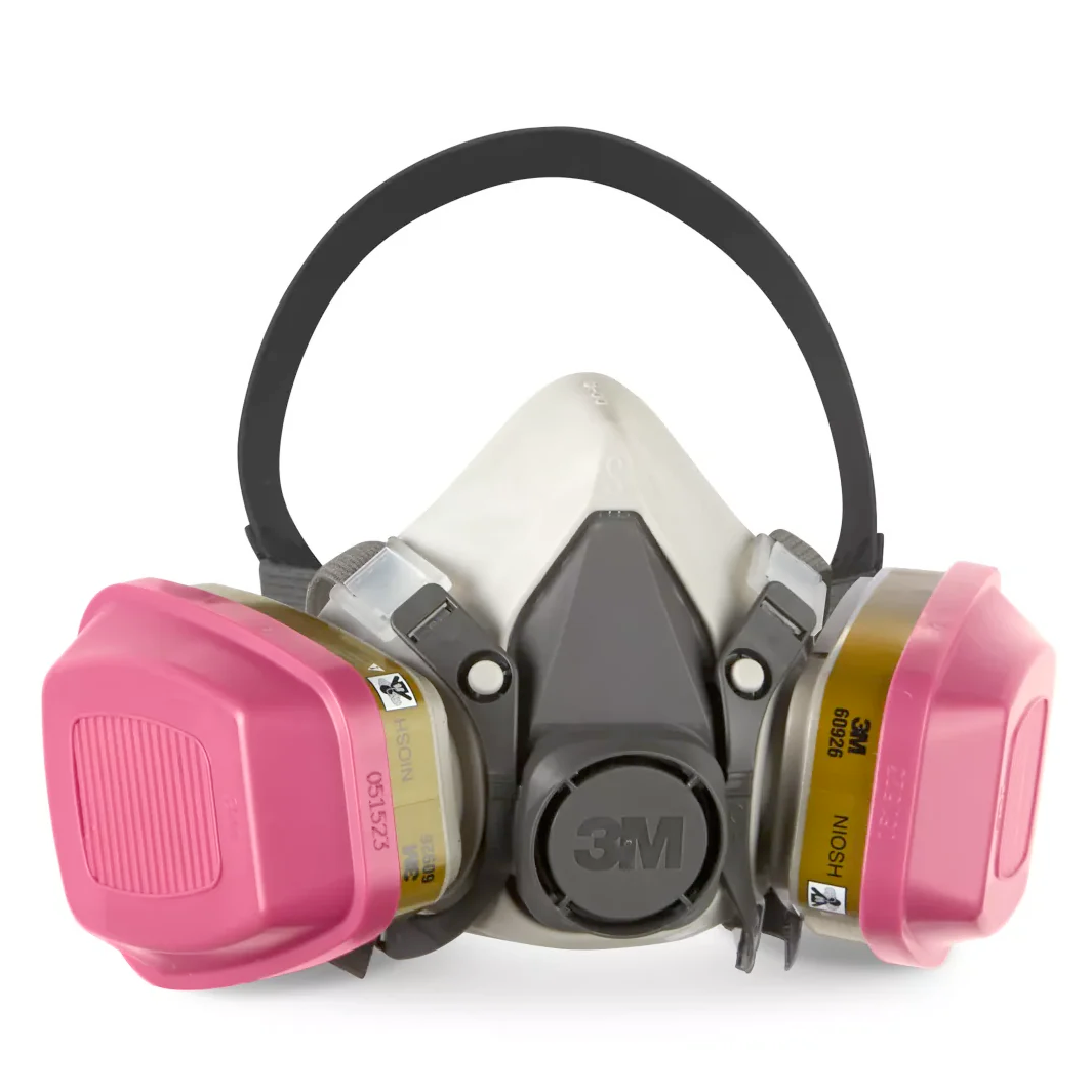 A half-face 3M P100 respirator with pink cartridges to filter organic vapor and acid gas.